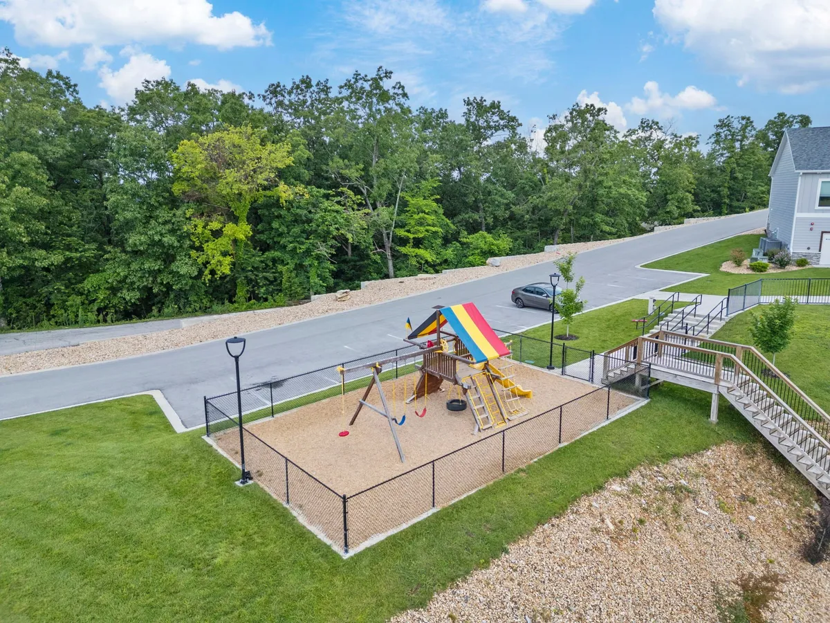 A colorful and lively playground with swings and climbing equipment under a bright canopy. Children are seen playing together, creating a joyful atmosphere ideal for family gatherings and community events.